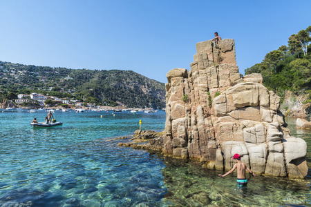 Girona, Spain - June 30, 2015: Aiguablava beach with sunbathers while a boat is heading to the beach in Costa Brava, Catalonia, Spainのeditorial素材