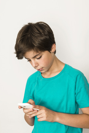 Boy touching a mobile phone isolated on white backgroundの写真素材