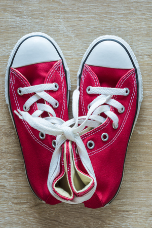 Pair of red sneakers seen from above on a parquet floorの写真素材