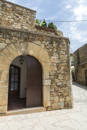 Pals, Girona, Spain - July 3, 2015: Medieval street within the medieval town of Pals. The Gothic Quarter of the town has been substantially restored and there are cobbled streets interrupted by semicircular arches, faÃ§ades with pointed arched windows andのeditorial素材