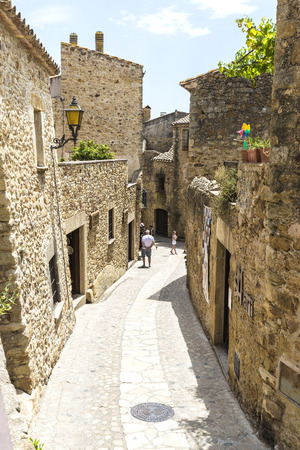 Pals, Girona, Spain - July 3, 2015: Tourists strolling through the medieval town of Pals.のeditorial素材
