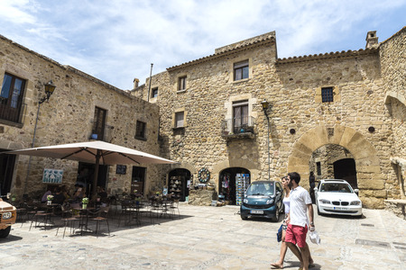 Pals, Girona, Spain - July 3, 2015: Tourists strolling through the medieval town of Pals.のeditorial素材