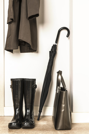 Raincoat, wellies, umbrella and bag ready for use in a rainy dayの写真素材