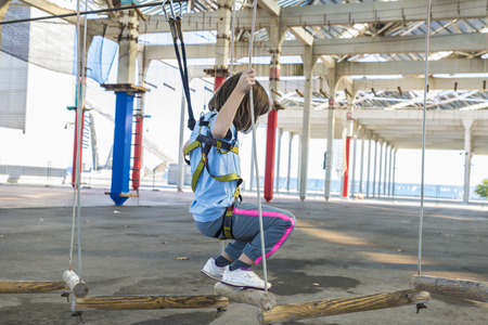 Little girl climbing in an urban park