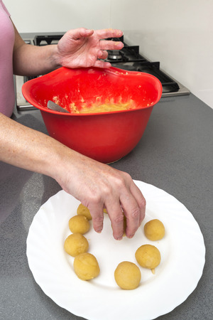 Woman kneading marzipan for make panellets  in the kitchen. Panellet are traditional desserts of All Saints holiday, known as Castanyada in Catalonia, Spainの写真素材