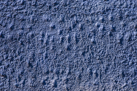 Closeup of a lilac blue rough wall to sunlightの写真素材