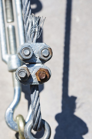 Turnbuckles fixed to the ground that hold the railing of a bridgeの写真素材
