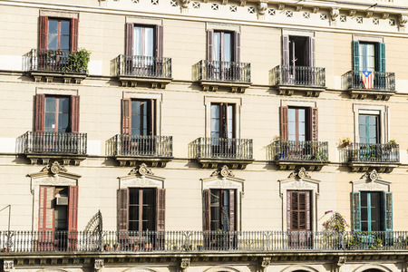Classical building of houses in the old town of Barcelona, Catalonia, Spain. On a balcony hangs the flag of Catalonia with the Esteladaの写真素材