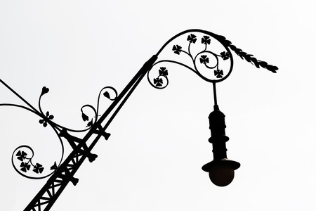 Silhouette of a street light decorated with leaves in Barcelona, Catalonia, Spainの写真素材