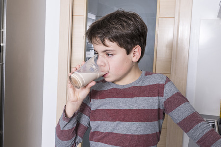 Young boy drinking a glass of chocolate milkの写真素材