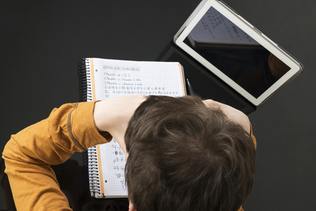 Teenage boy studying and using digital tablet at homeの写真素材
