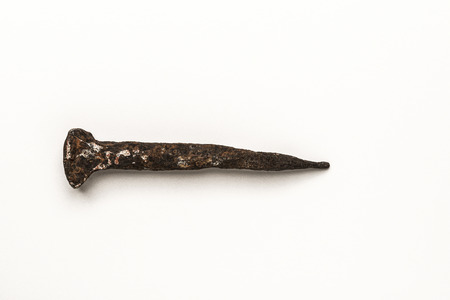 Close-up of old rusty nail isolated on white backgroundの写真素材