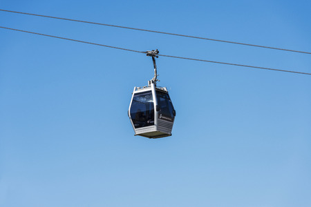 Barcelona, Spain - April 15, 2016: Cable way against the blue sky in the mountain of Montjuic. Inside the cabin, some tourists enjoy the sceneryのeditorial素材
