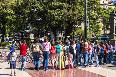 Barcelona, Spain - May 4, 2016: School children playing to scare away pigeons in Placa Catalunyaのeditorial素材