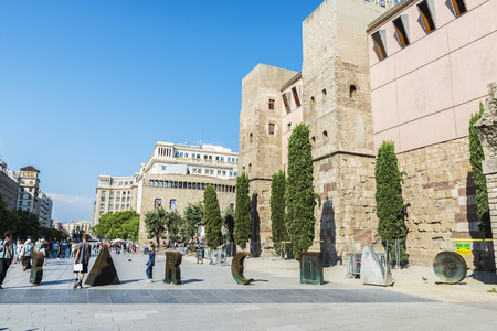 Barcelona, Spain - June 1, 2016: The word Barcino made metal parts next to the ancient wall full of tourists in the old town of Barcelonaのeditorial素材