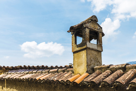 Old chimney of a house on a ceramic tiled roofの写真素材
