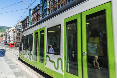 Bilbao, Spain - August 13, 2016: Tram running through the center of Bilbao and people walkingのeditorial素材