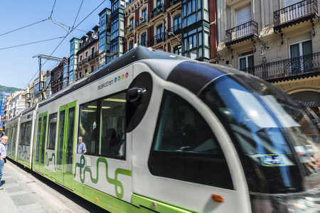 Bilbao, Spain - August 13, 2016: Tram running through the center of Bilbao and people walkingのeditorial素材