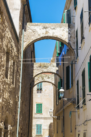 Street of the old town with arches and hanging clothing in Alghero, Sardinia, Italyの写真素材