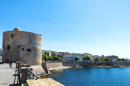 Alghero, Italy - August 26, 2016: Tower of the fortification in the old town with people walking in Alghero, Sardinia, Italyのeditorial素材