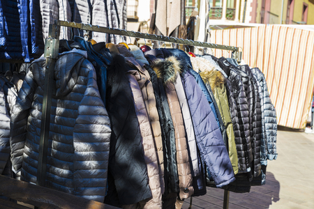 Row of coats and anoraks in a flea market in Spainの写真素材