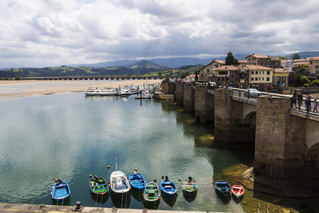 Overview of fishing boats in the harbor in the village of San Vicente de la Barquera in Cantabria, Spainの写真素材