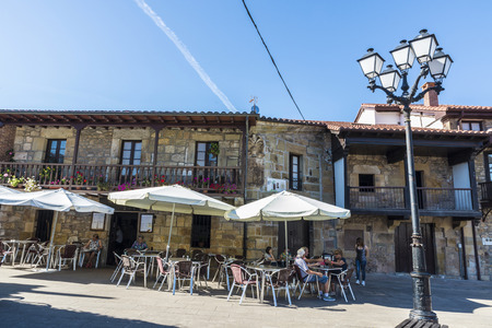 Lierganes, Spain - August 11, 2016: Restaurant and bar terraces with people sitting on the street in the medieval village of Lierganes in Cantabria, Spainのeditorial素材