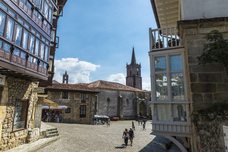 Comillas, Spain - August 11, 2016: Street with old historic building with people walking in the...