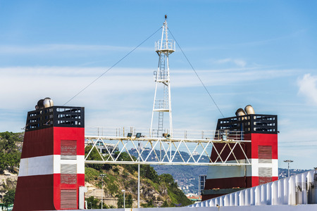 Red smokestack of a cargo ship with its look-out in the port of Barcelona, Catalonia, Spainの写真素材
