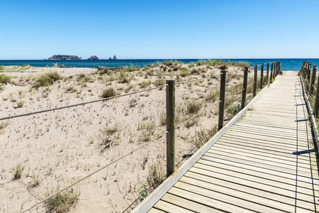 Wooden path to the beach of Pals with the Medes islands in the background in Costa Brava, Girona, Catalonia, Spainの写真素材