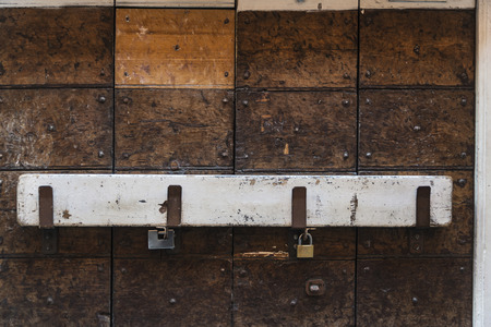 Closed wooden door with padlock and a white wooden beam as background in Rome, Italyの写真素材