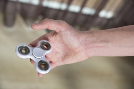 Young boy playing with fidget spinner toy to relieve stress at homeの写真素材