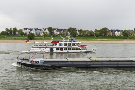 Dusseldorf, Germany - April 16, 2017: Merchant ship and cruise ship sailing on the Rhine River in Dusseldorf, Germanyのeditorial素材