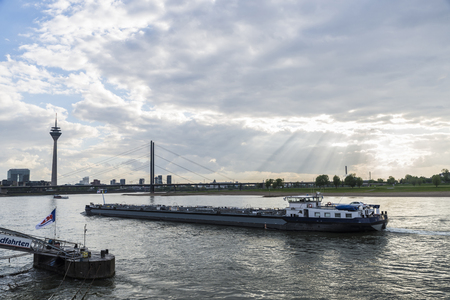 Dusseldorf, Germany - April 16, 2017: Merchant ship sailing on the Rhine River at dusk in Dusseldorf, Germanyのeditorial素材