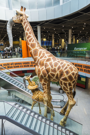 Dusseldorf, Germany - April 17, 2017: Decoration giraffes inside Dusseldorf airport with people walking in Dusseldorf, Germanyのeditorial素材