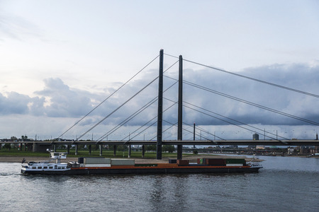 Cargo ship loaded with containers sailing on the Rhine River in Dusseldorf, Germanyの写真素材