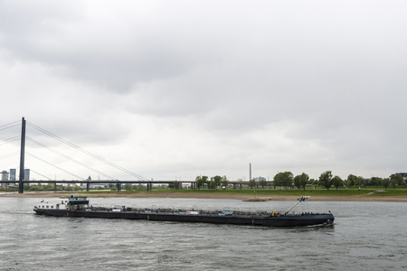 Cargo ship sailing on the Rhine River in Dusseldorf, Germanyの写真素材