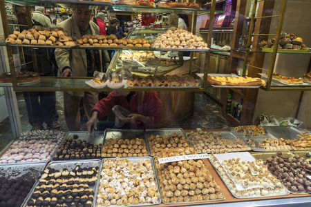 Cardona, Spain - October 30, 2016: Assortment of panellets in the shop window of a pastry shop with customers choosing. Panellet are traditional desserts of All Saints holiday, known as Castanyada in Cardona, Catalonia, Spainのeditorial素材