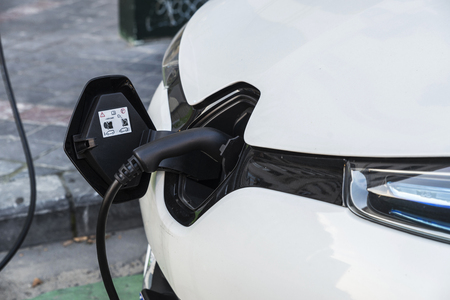 Electric car recharging batteries at a recharge point on a street in Brussels, Belgiumの写真素材