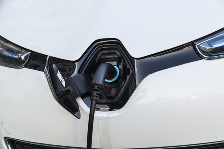 Electric car recharging batteries at a recharge point on a street in Brussels, Belgiumの写真素材