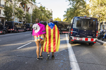 Barcelona, Spain - September 20, 2017: Couple walking between police cars towards demonstration for independence of Cataloniaのeditorial素材