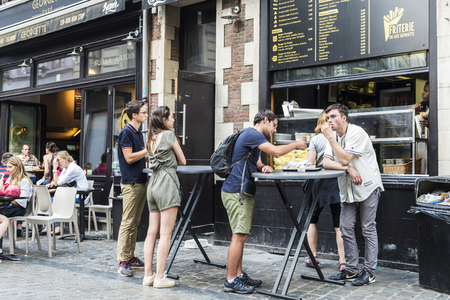 Brussels, Belgium - August 26, 2017: People eating french fries in a bar on the street in Brussels, Belgiumのeditorial素材