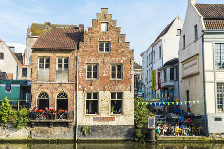 Ghent, Belgium - August 28, 2017: Tourists in a bar between old houses along the Leie river in Ghent, Belgiumのeditorial素材