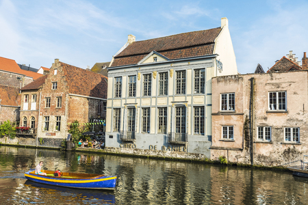 Ghent, Belgium - August 28, 2017: Young man sailing with a boat between old houses along the Leie river in Ghent, Belgiumのeditorial素材