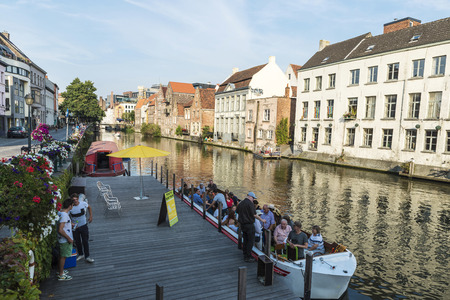 Ghent, Belgium - August 28, 2017: Tourists sailing with a boat between old houses along the Leie river in Ghent, Belgiumのeditorial素材