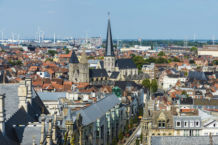 View of the old town of the historic city of Ghent in Belgium with wind energy mills in the backgroundの写真素材