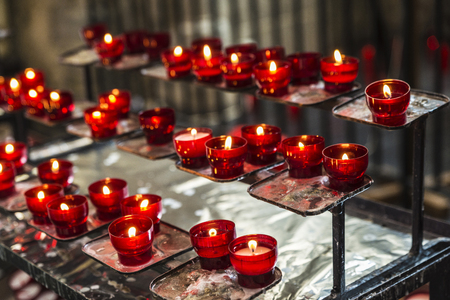 Red candles in the Saint Bavo Cathedral (also known as Sint-Baafs Cathedral) in an old historic center of the medieval city of Ghent, Belgiumの写真素材