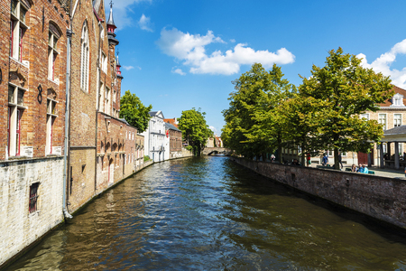 Bruges, Belgium, - August 31, 2017: Old traditional houses along of a canal with people around in the medieval city of Bruges, Belgiumのeditorial素材