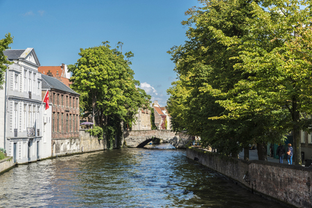 Bruges, Belgium, - August 31, 2017: Old traditional houses along of a canal with people around in the medieval city of Bruges, Belgiumのeditorial素材