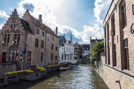 Bruges, Belgium, - August 31, 2017: Old traditional houses along of a canal with people around in the medieval city of Bruges, Belgiumのeditorial素材
